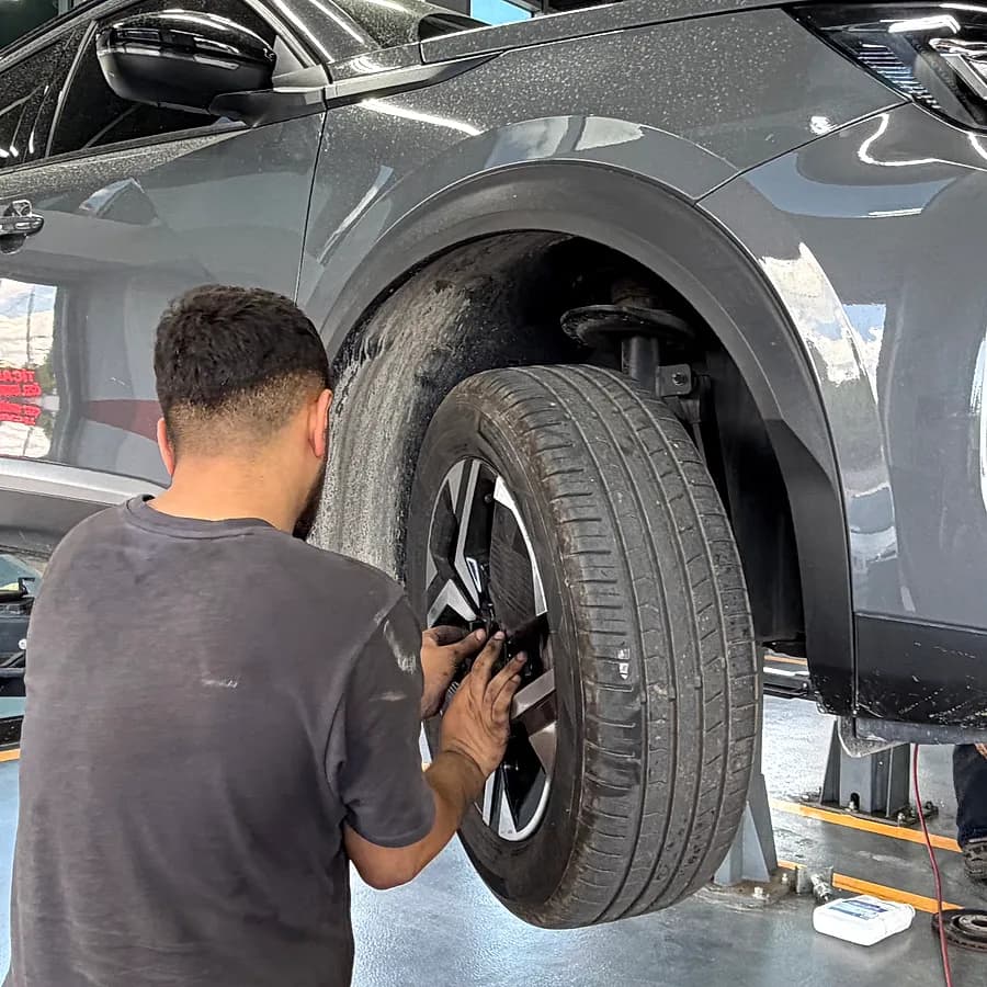 Teknisyen müşteri aracının lastik ve jantını kontrol ediyor